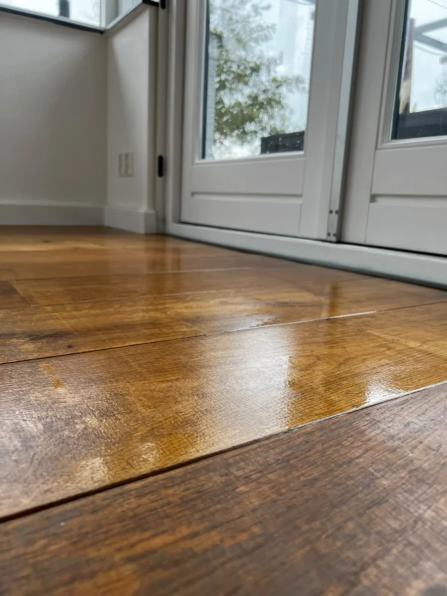 Glanzend gelakte houten vloer bij witte tuindeuren